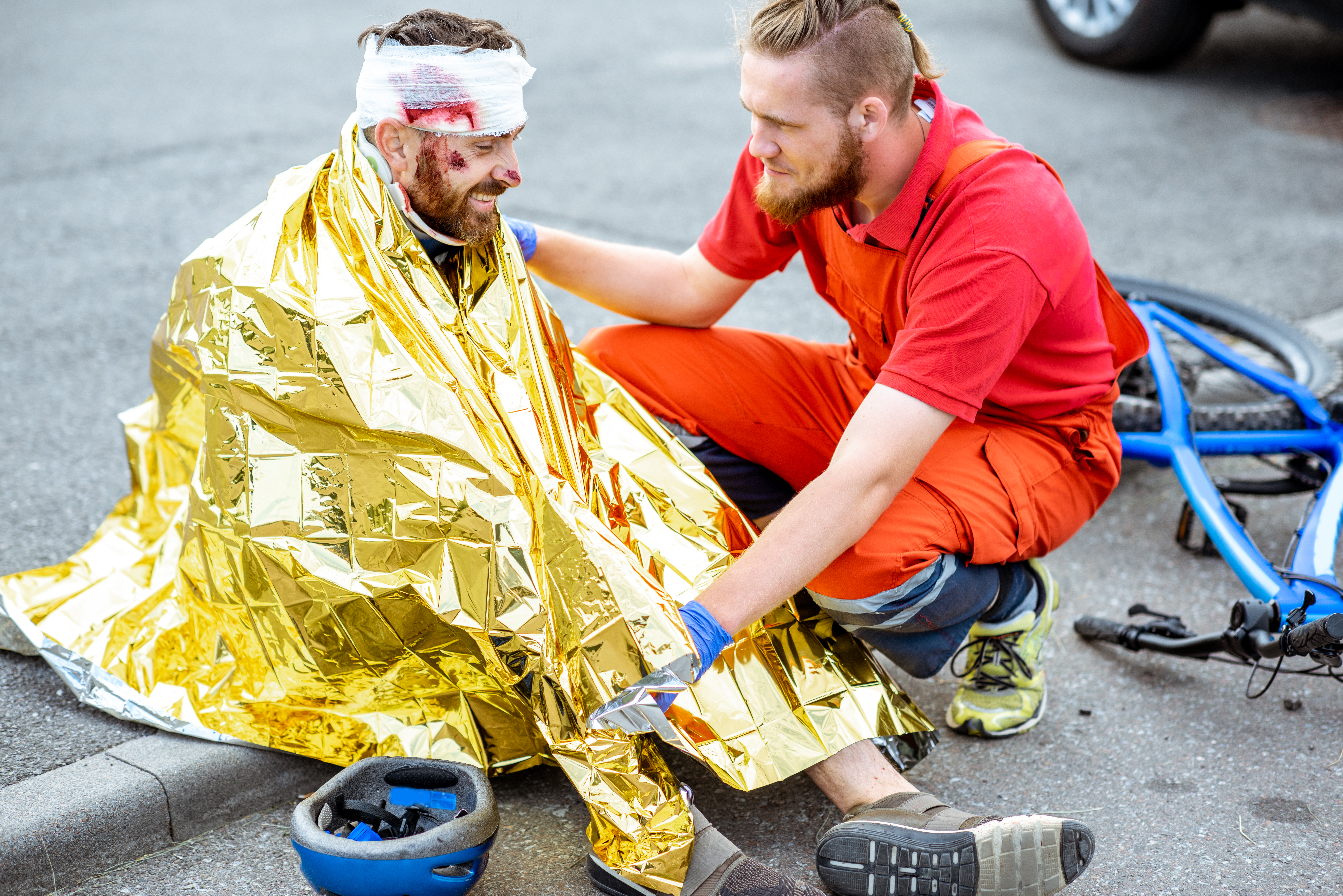 Medic covering victim with thermal blanket after the accident