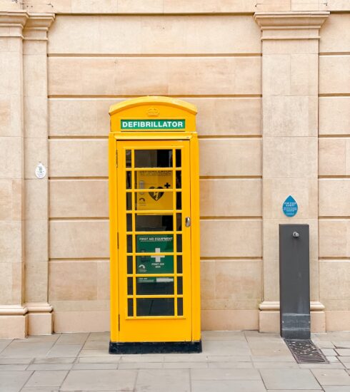yellow telephone booth beside beige concrete building